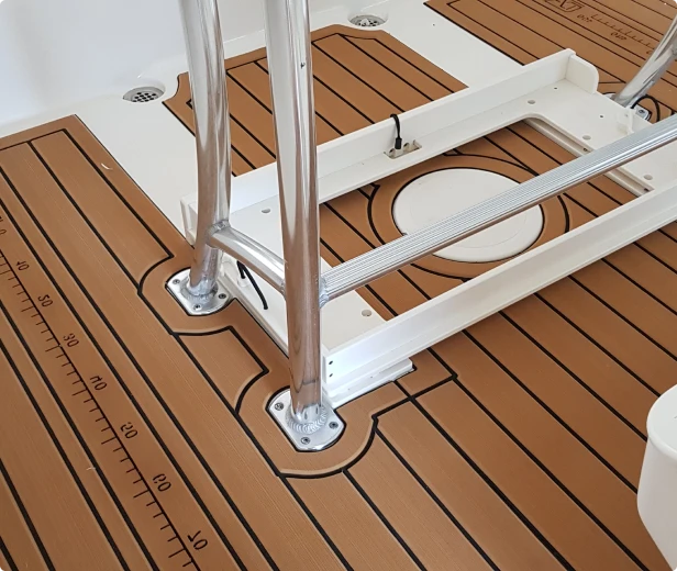 Close-up of a boat deck featuring teak-style custom decking with integrated measurement markings, complemented by sturdy chrome fixtures